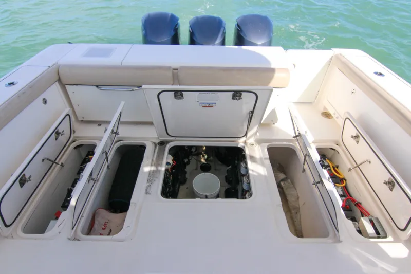 Slide: The Image of 2016 Pursuit OS 385 Offshore boat deck with open storage compartments and visible engines. - 42