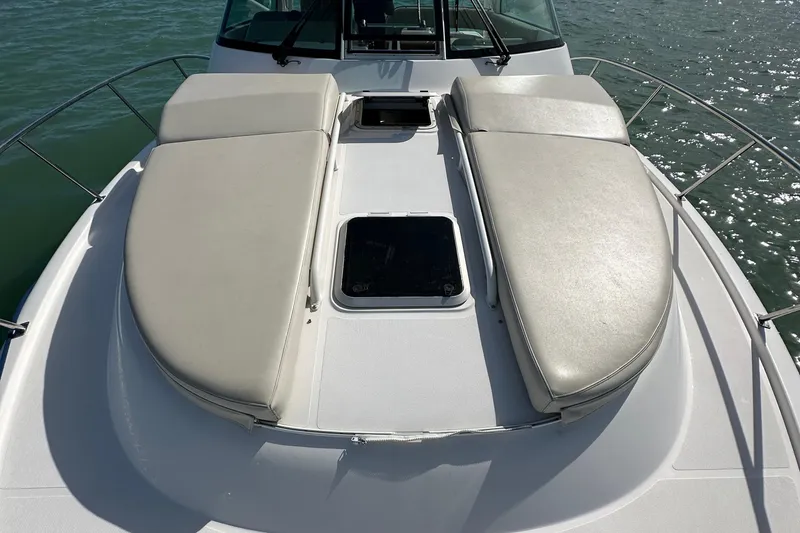 Slide: The Image of 2016 Pursuit OS 385 Offshore boat with cushioned deck seating on calm water. - 45