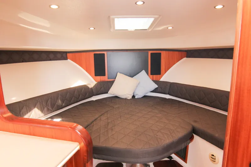 Slide: The Image of 2016 Pursuit OS 385 Offshore cabin interior with cozy seating and cushions. - 53