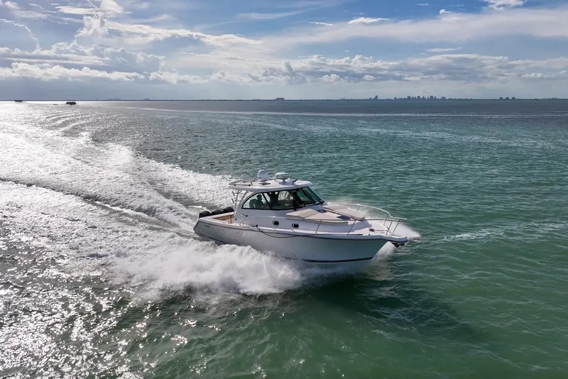 Slide: The Image of 2016 Pursuit OS 385 Offshore cruising on open water under a partly cloudy sky. - 7