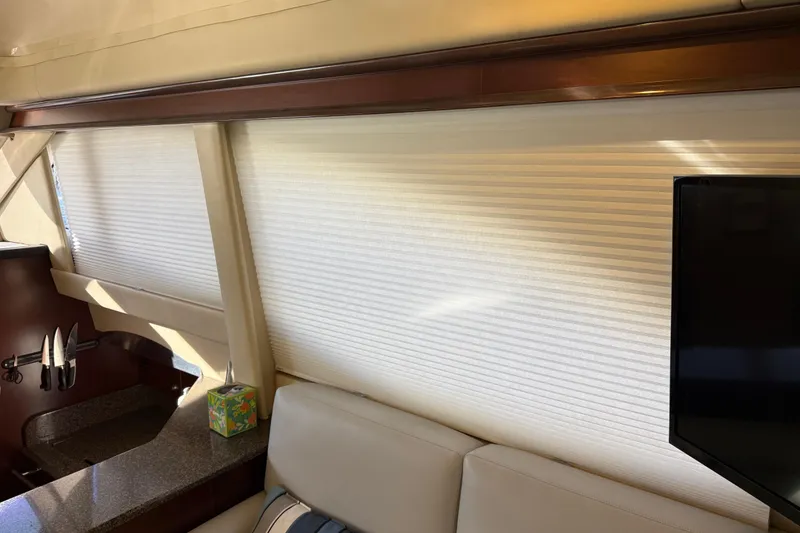 Slide: The Image of Interior of 2006 Sea Ray 44 Sedan Bridge with blinds, sofa, and mounted TV. - 14
