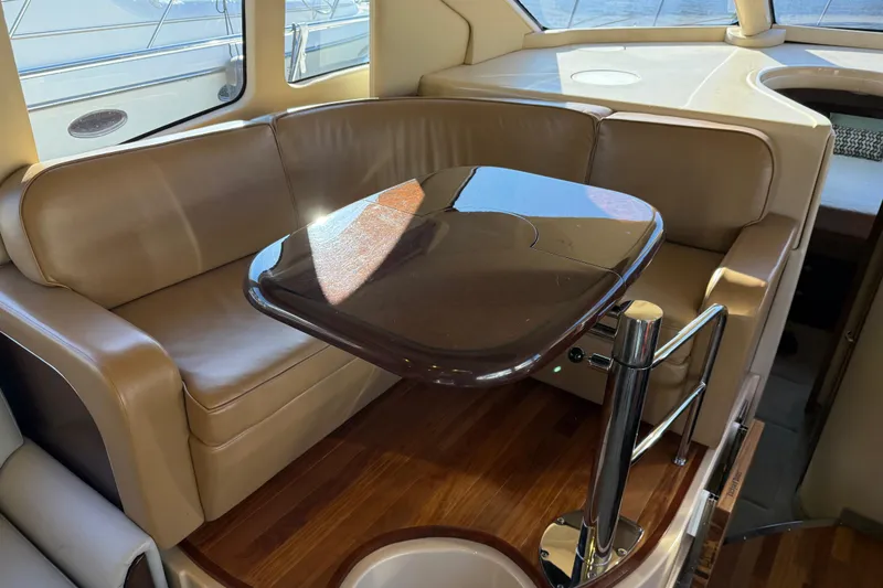Slide: The Image of Luxurious interior of 2006 Sea Ray 44 Sedan Bridge with leather seating and wooden table. - 17