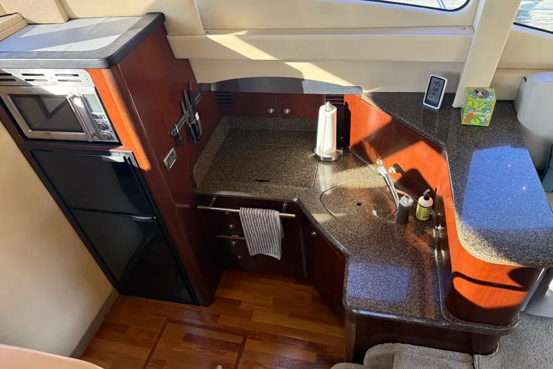 Slide: The Image of 2006 Sea Ray 44 Sedan Bridge kitchen with granite countertops and modern appliances. - 23