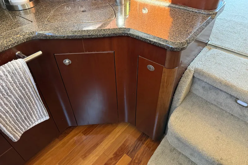Slide: The Image of 2006 Sea Ray 44 Sedan Bridge interior with wooden cabinetry and carpeted stairs. - 28