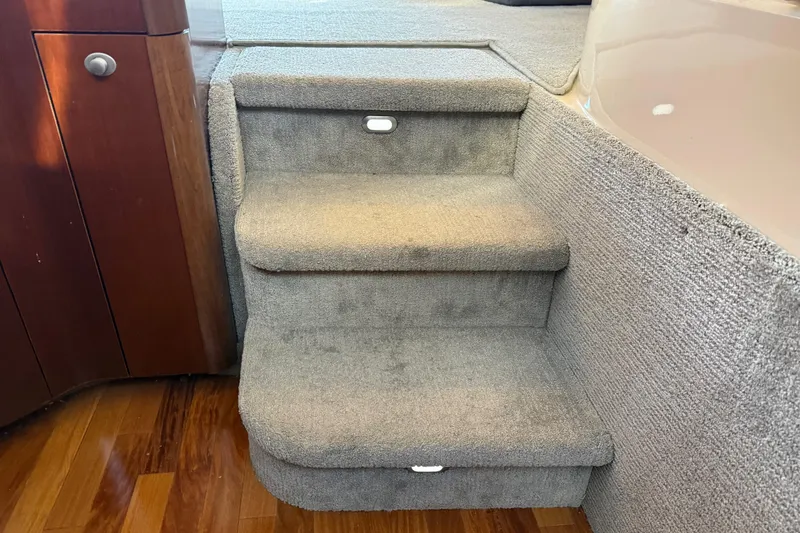 Slide: The Image of Carpeted stairs inside 2006 Sea Ray 44 Sedan Bridge yacht, featuring wooden accents. - 30