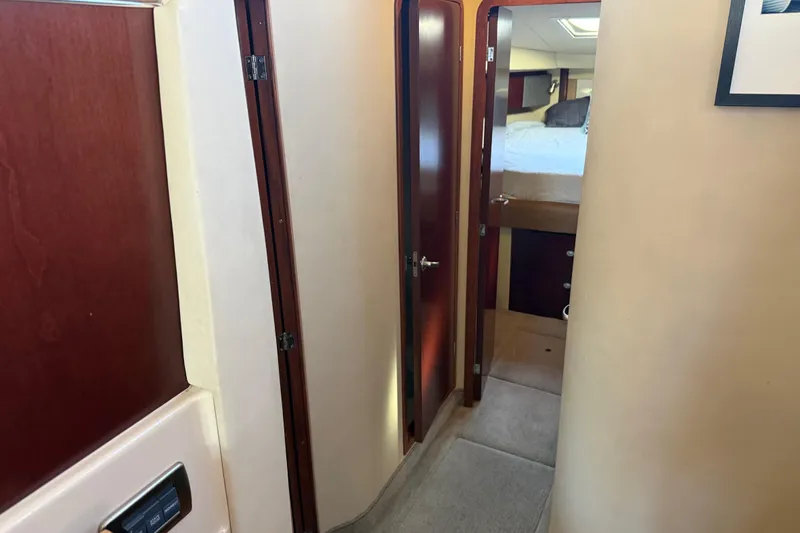 Slide: The Image of Interior hallway of 2006 Sea Ray 44 Sedan Bridge yacht, featuring wooden doors and carpet. - 34