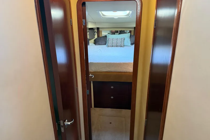 Slide: The Image of 2006 Sea Ray 44 Sedan Bridge cabin interior with bed and wooden door. - 35