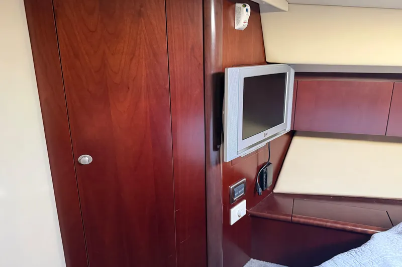 Slide: The Image of Interior of 2006 Sea Ray 44 Sedan Bridge with wood paneling and wall-mounted TV. - 39