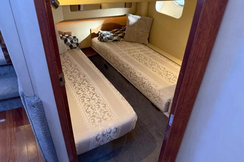 Slide: The Image of 2006 Sea Ray 44 Sedan Bridge cabin with twin beds and decorative pillows. - 49