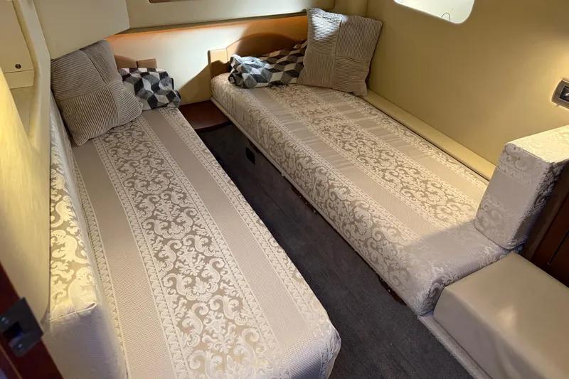 Slide: The Image of 2006 Sea Ray 44 Sedan Bridge cabin with twin beds and decorative pillows. - 50
