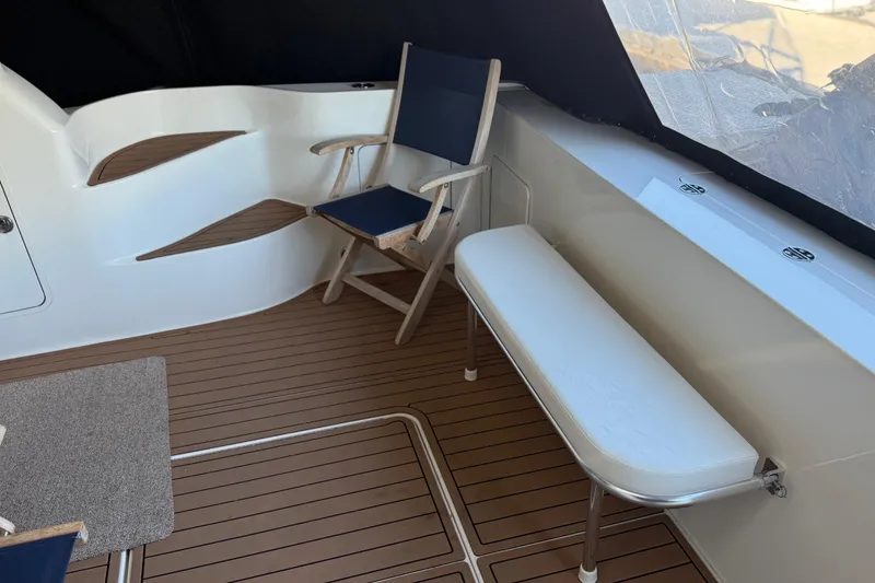 Slide: The Image of 2006 Sea Ray 44 Sedan Bridge interior with seating and wood-style flooring. - 6