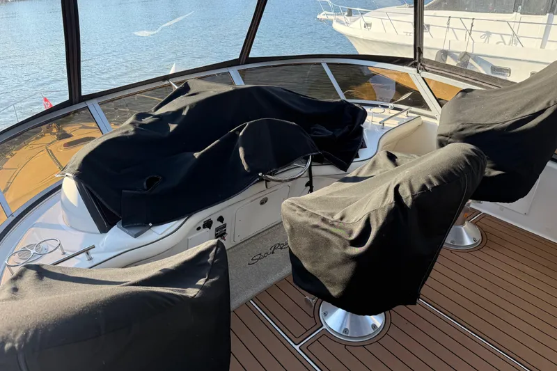 Slide: The Image of 2006 Sea Ray 44 Sedan Bridge helm with covered seats, overlooking water. - 62