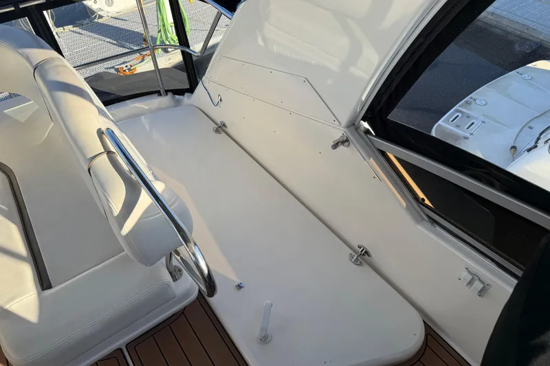 Slide: The Image of 2006 Sea Ray 44 Sedan Bridge interior with white seating and polished railings. - 77