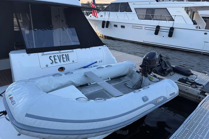 Slide: The Image of 2006 Sea Ray 44 Sedan Bridge yacht with inflatable dinghy docked at marina. - 93