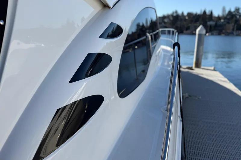 Slide: The Image of 2006 Sea Ray 44 Sedan Bridge yacht docked by serene waters. - 98