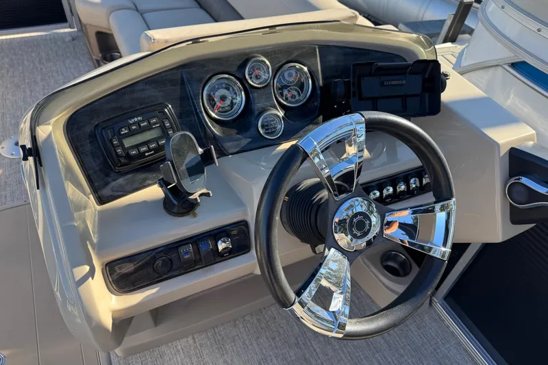 Slide: The Image of Steering console of 2021 Avalon LSZ 2485 boat with chrome accents and gauges. - 19