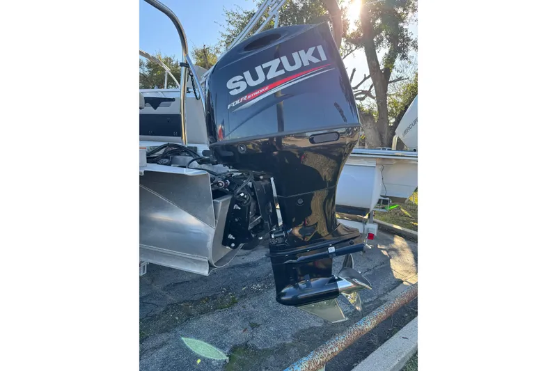 Slide: The Image of Suzuki outboard motor on 2021 Avalon LSZ 2485 boat, parked outdoors. - 28