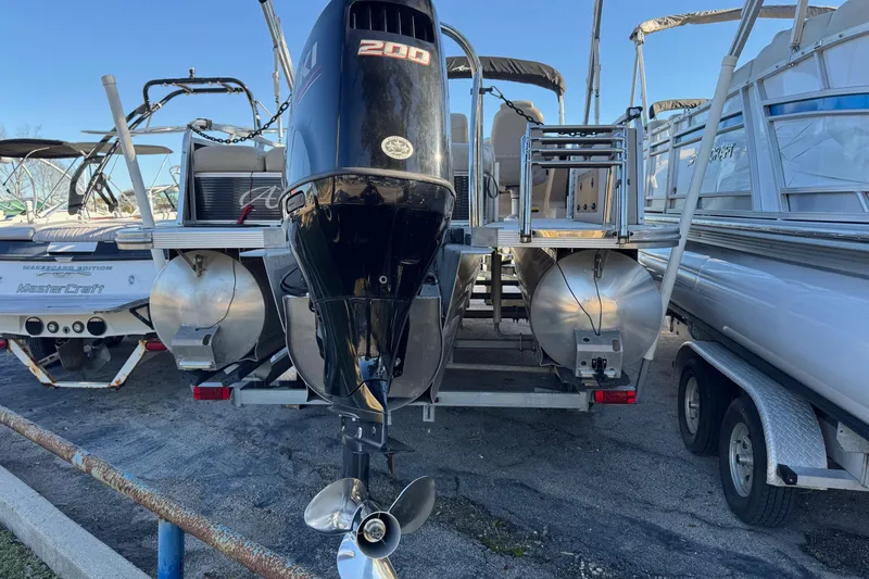 Slide: The Image of 2021 Avalon LSZ 2485 pontoon boat with powerful outboard motor, docked alongside other boats. - 29