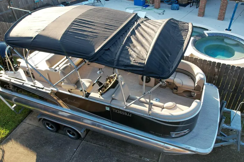 Slide: The Image of 2021 Avalon LSZ 2485 pontoon boat with canopy on trailer, parked in backyard. - 4