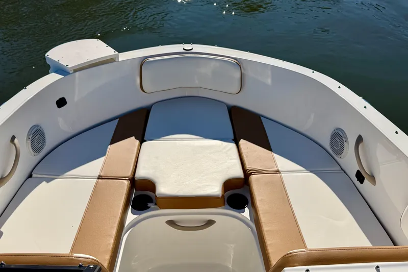 Slide: The Image of 2023 Bayliner VR4 Bowrider OB interior with tan and white seating, on calm water. - 10