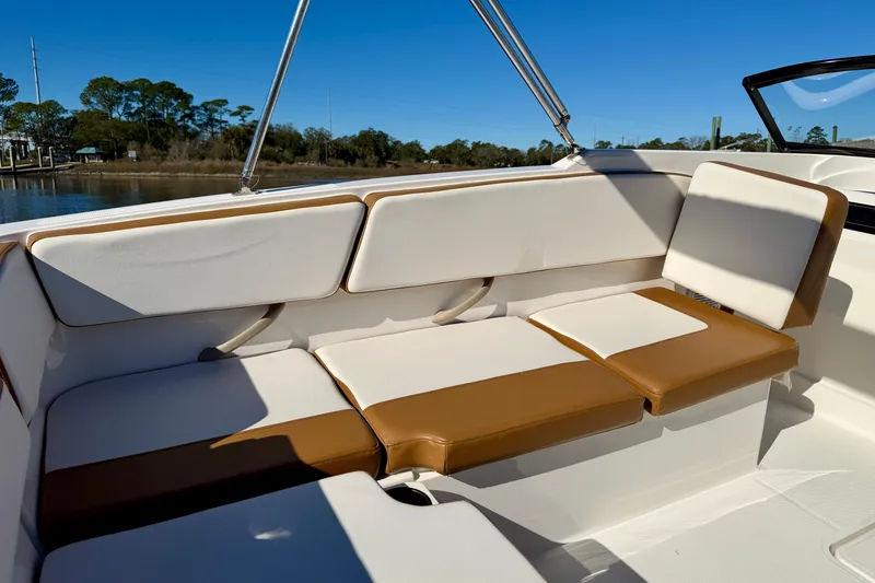 Slide: The Image of 2023 Bayliner VR4 Bowrider OB interior with tan and white seating, sunny day. - 17
