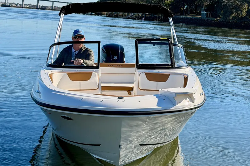 Slide: The Image of 2023 Bayliner VR4 Bowrider OB on calm water, featuring sleek design and spacious seating. - 2