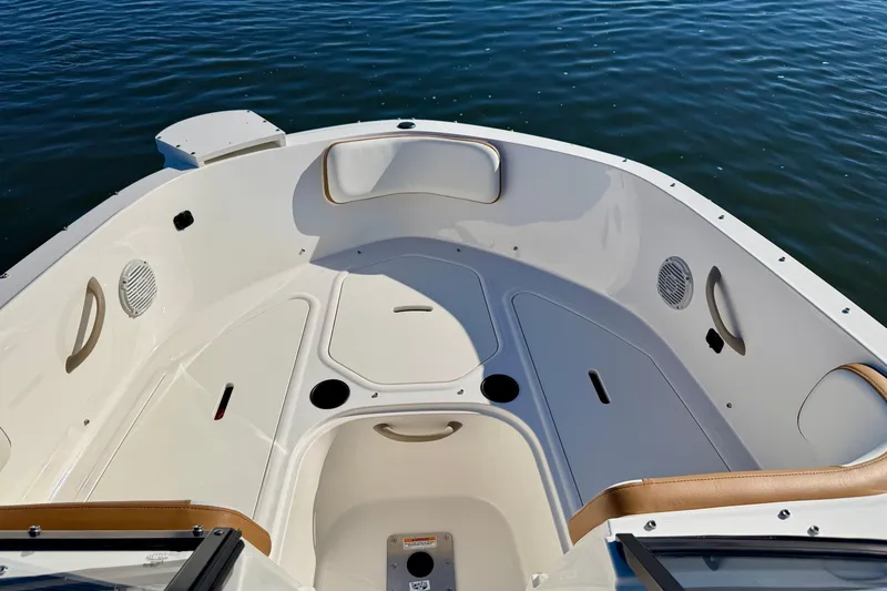 Slide: The Image of 2023 Bayliner VR4 Bowrider OB interior with seating and storage, on calm water. - 22