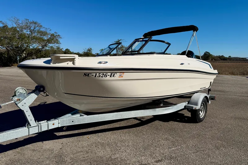 Slide: The Image of 2023 Bayliner VR4 Bowrider OB on trailer, parked outdoors under clear blue sky. - 28