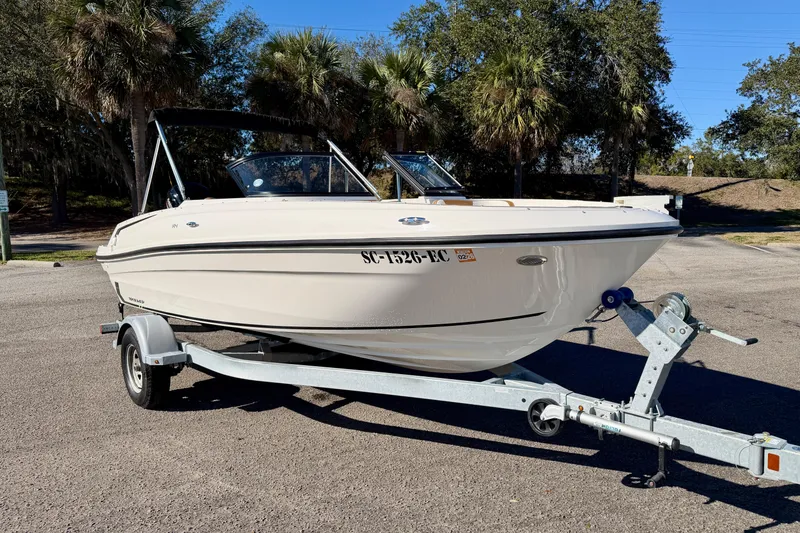 Slide: The Image of 2023 Bayliner VR4 Bowrider OB on trailer, parked outdoors with trees in background. - 29