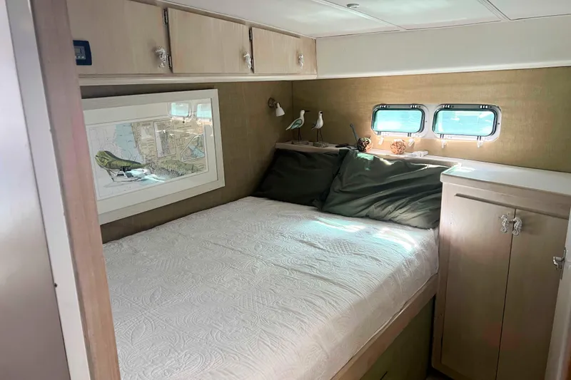 Slide: The Image of Cozy bedroom in 1986 Bertram 42 Convertible yacht with nautical decor and natural light. - 13