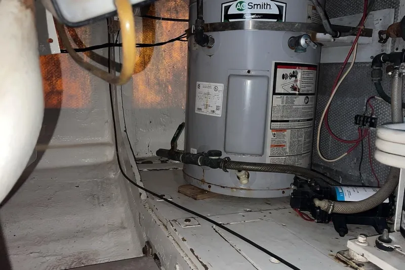 Slide: The Image of Engine room of 1980 Bertram 42 Convertible with water heater and wiring. - 21