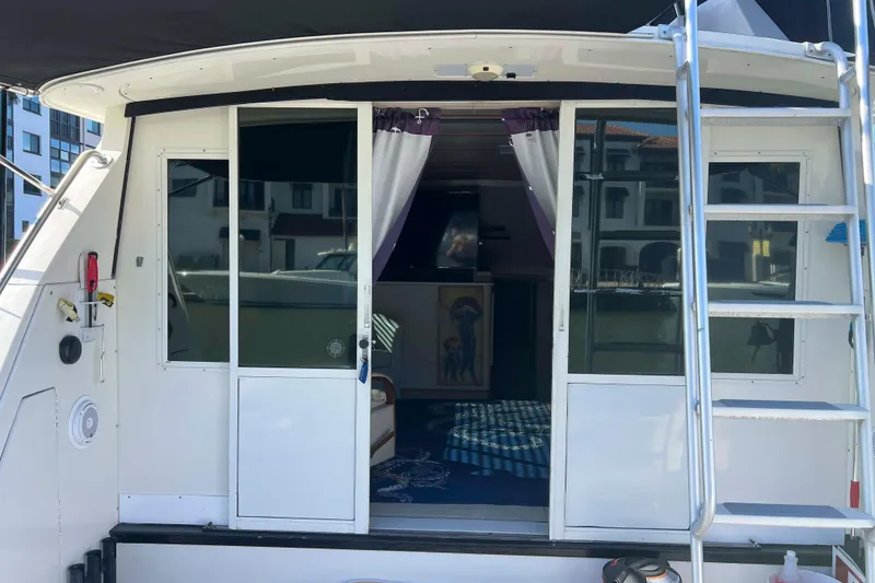 Slide: The Image of 1986 Bertram 42 Convertible yacht with open sliding doors and visible interior. - 5