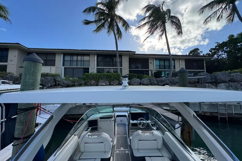 Slide: The Image of 2024 Regal LX9 boat docked near waterfront property with palm trees. - 13