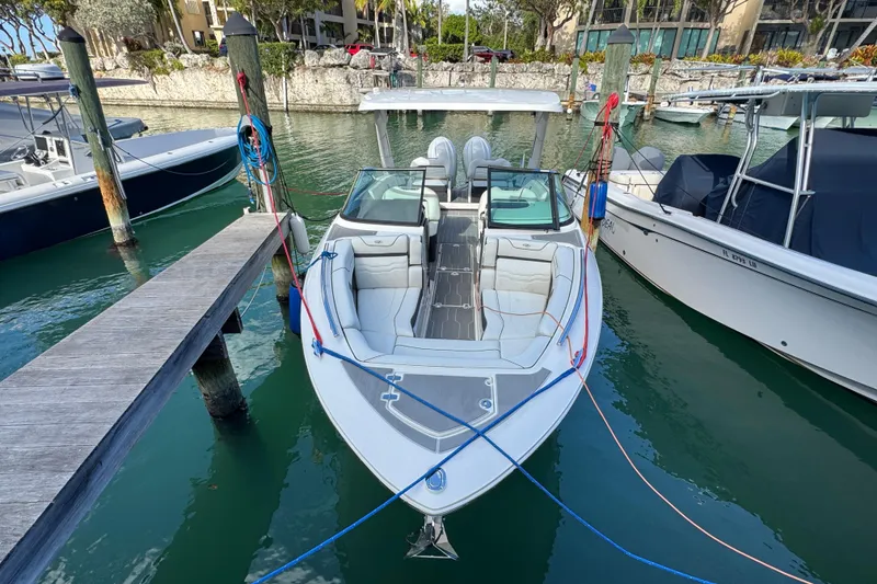 Slide: The Image of 2024 Regal LX9 boat docked in marina, surrounded by water and neighboring vessels. - 2