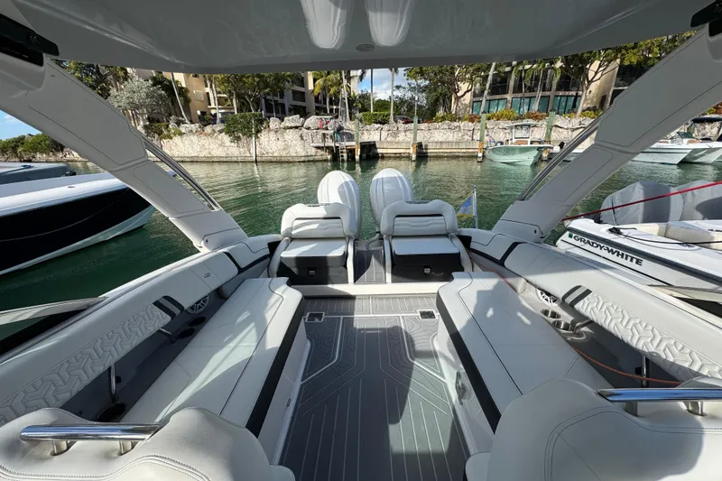 Slide: The Image of 2024 Regal LX9 boat interior with luxurious seating and modern design in a marina setting. - 6