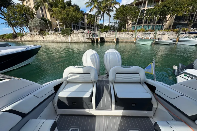 Slide: The Image of 2024 Regal LX9 boat with luxurious seating, docked in a scenic marina. - 7