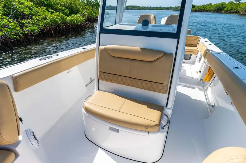 Slide: The Image of Manufacturer Provided Image: 2025 Sportsman Heritage 261 Center Console boat interior with tan seating, on a sunny day. - 13
