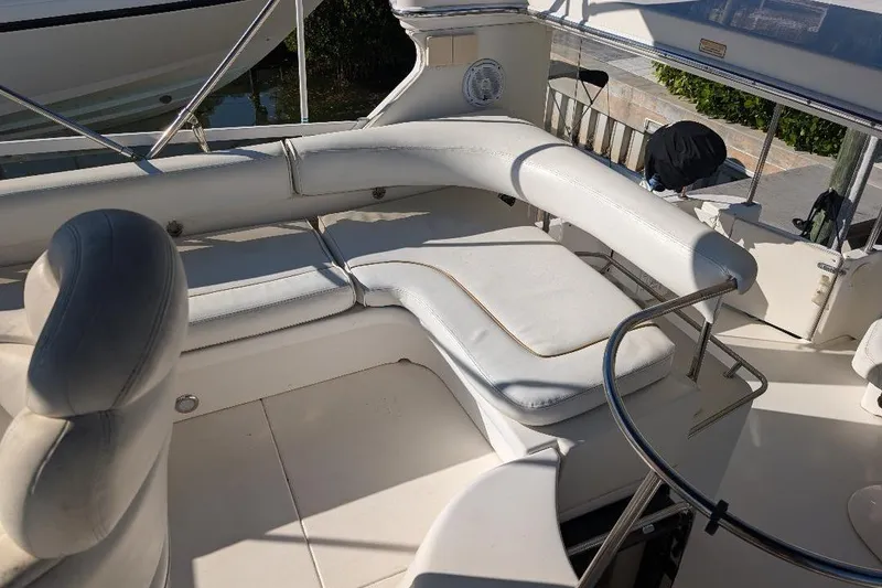 Slide: The Image of 2000 Sea Ray 420 Aft Cabin boat interior with white cushioned seating. - 8