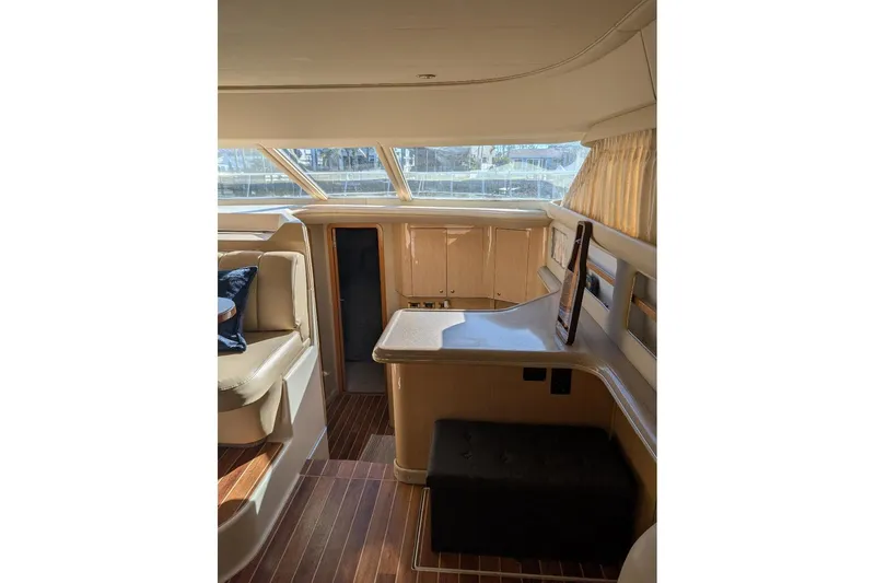Slide: The Image of 2000 Sea Ray 420 Aft Cabin boat interior with wooden table and cushioned seating. - 9