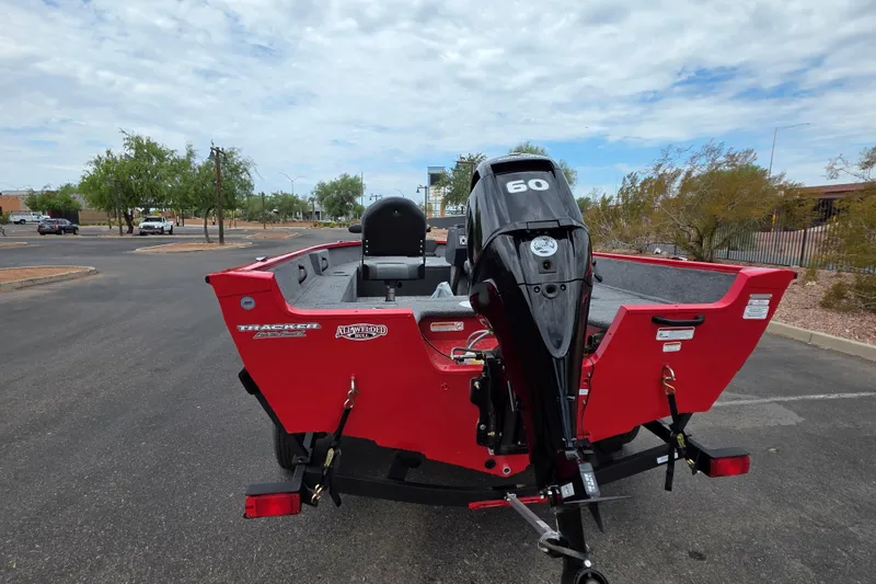 Slide: The Image of 2026 Tracker Pro Guide V-16 SC boat with 60 HP motor, parked outdoors. - 3