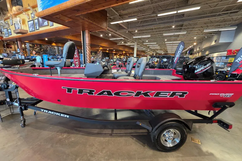 Slide: The Image of 2026 Tracker Pro Guide V-16 SC boat displayed in showroom, featuring vibrant red color and Mercury engine. - 4