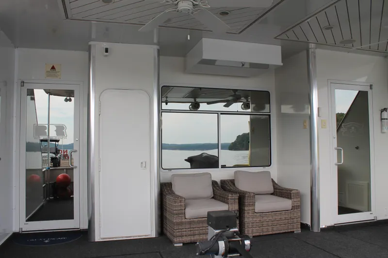 Slide: The Image of 2008 Sharpe 105 Custom Houseboat interior with wicker chairs and lake view. - 17