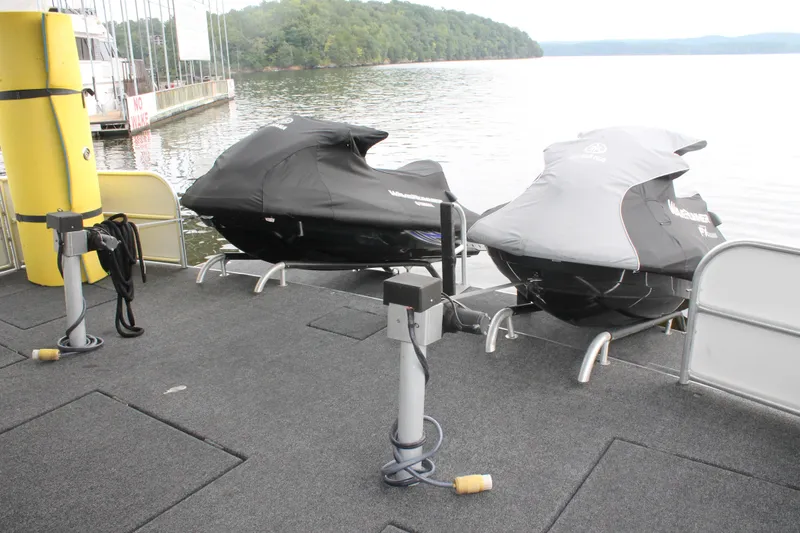 Slide: The Image of Two covered jet skis on a 2008 Sharpe 105 Custom Houseboat deck by a lake. - 18