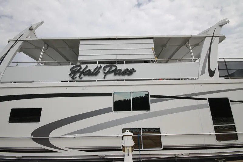 Slide: The Image of 2008 Sharpe 105 Custom Houseboat with modern design and "Hall Pass" signage. - 23
