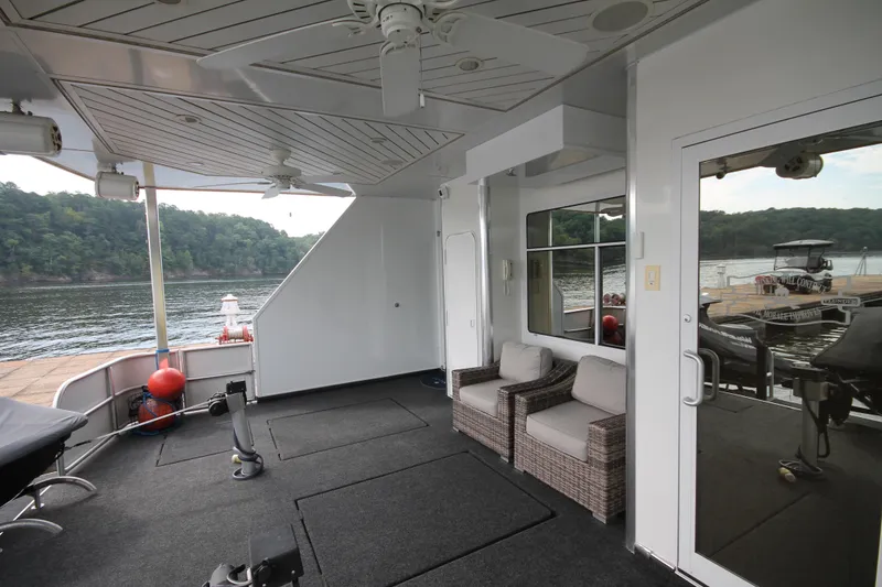Slide: The Image of 2008 Sharpe 105 Custom Houseboat interior with seating, ceiling fan, and lake view. - 25