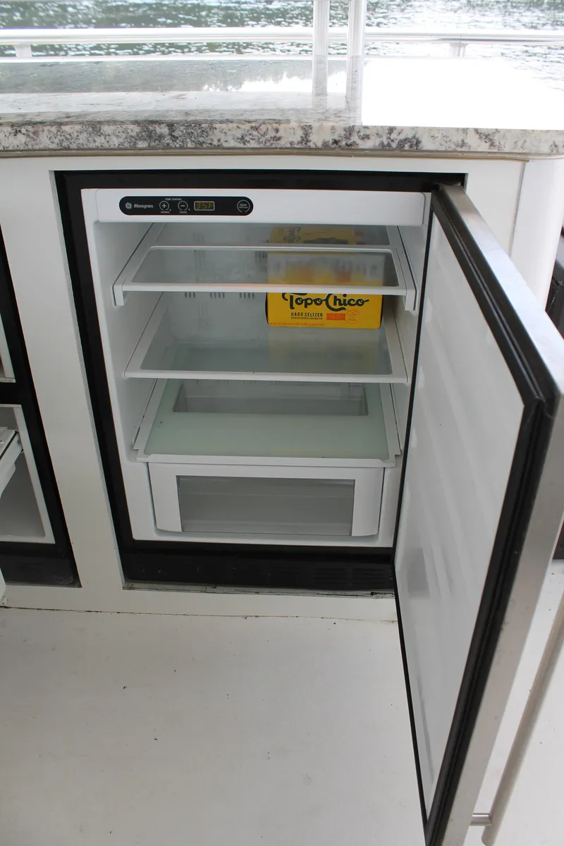 Slide: The Image of Open mini fridge on 2008 Sharpe 105 Custom Houseboat with Topo Chico box inside. - 45