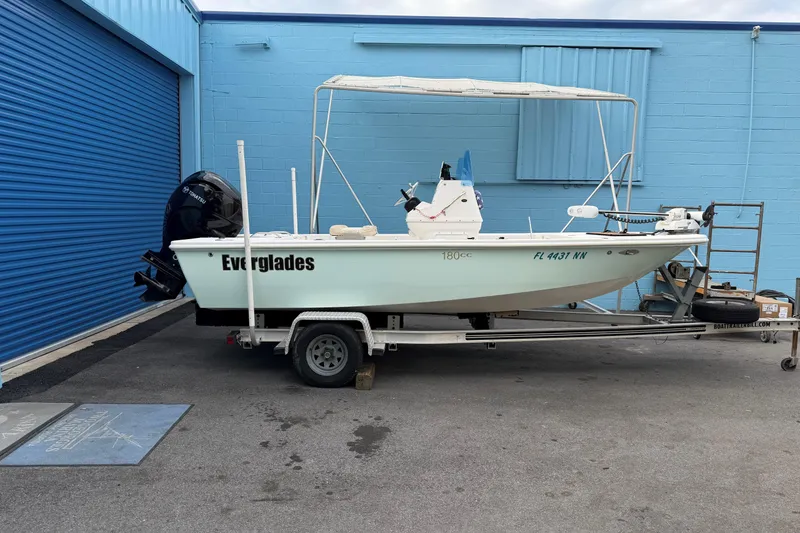 Slide: The Image of 2004 Everglades 180 Center Console boat on trailer outside a blue building. - 1
