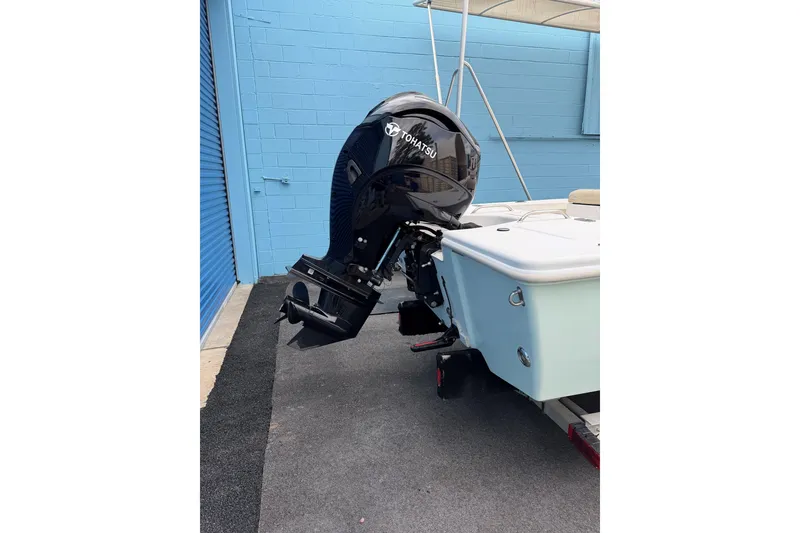 Slide: The Image of 2004 Everglades 180 Center Console boat on trailer, parked by blue storage unit. - 2