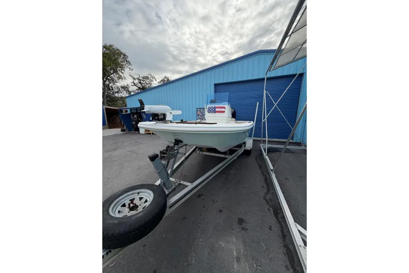 Slide: The Image of 2004 Everglades 180 Center Console boat with Tohatsu outboard motor, parked near blue wall. - 3