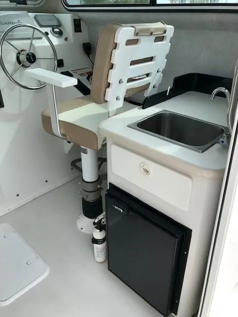 Slide: The Image of Interior of 2017 Parker 2520 XL Sport Cabin with seat, sink, and fridge. - 14